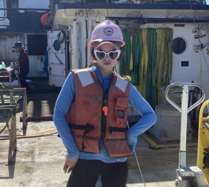Woman posing on deck of a research vessel in life jacket.