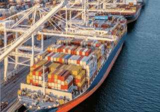 Large ships docked at the Port of Oakland in the Bay area with city in background